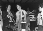 Woman with her trophy among banquet attendees, circa 1980s by Clark University