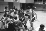 Coach for JV basketball team talks to players, 1985 by Clark University and Teri Buch