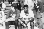 Two men's basketball team players sitting down, 1985 by Clark University and Chip Schilling
