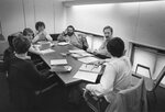 A small discussion group sits at a table, 1977 by Clark University and Chuck Kidd