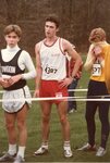 Candid shot of men's cross country team member between opponents, 1986 by Clark University