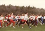 Women’s cross country team members and competitors run at meet, 1986 by Clark University and Mitch Cohen